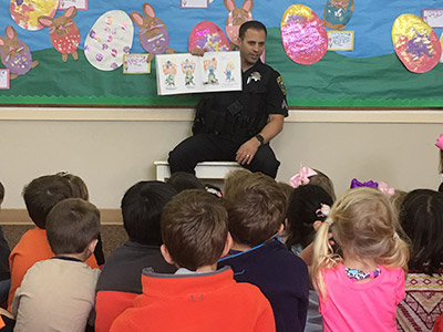 police officer reading a story to children