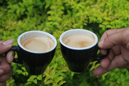 two hands each holding a coffee mug