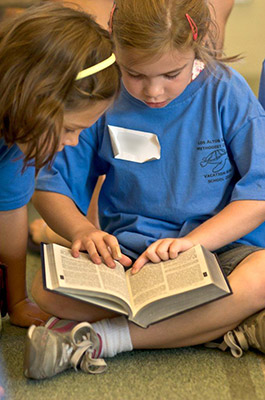 two girls read the bible together