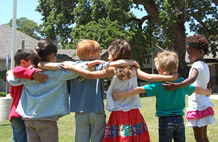 children with arms around each others shoulders
